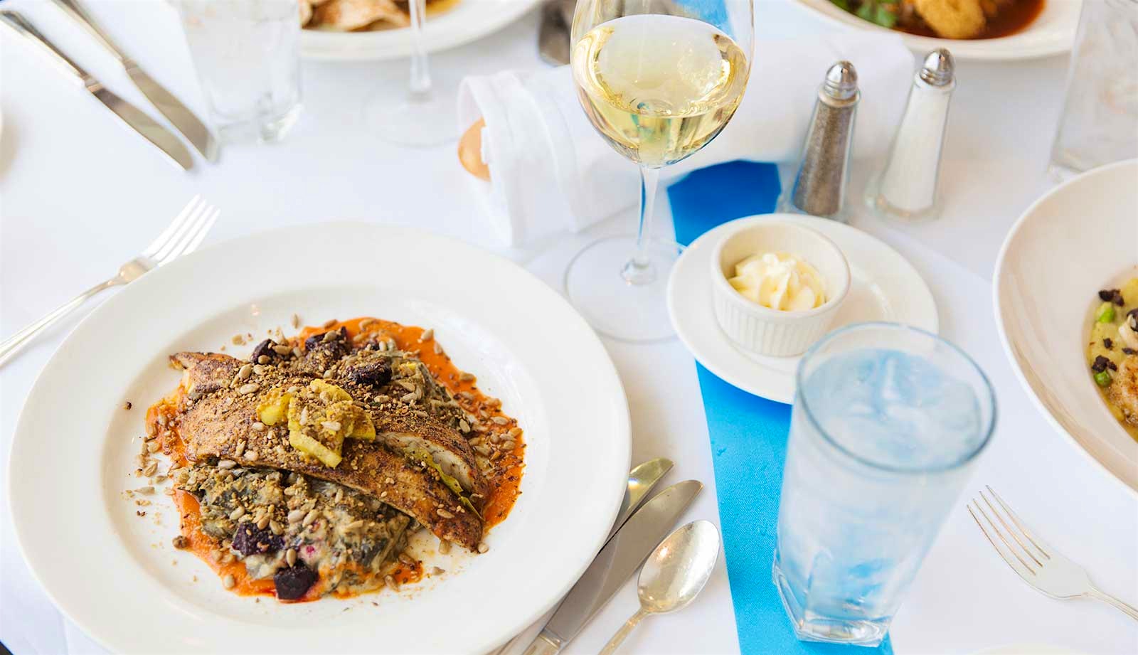 Seared Gulf fish from Commander’s Palace with a glass of white wine